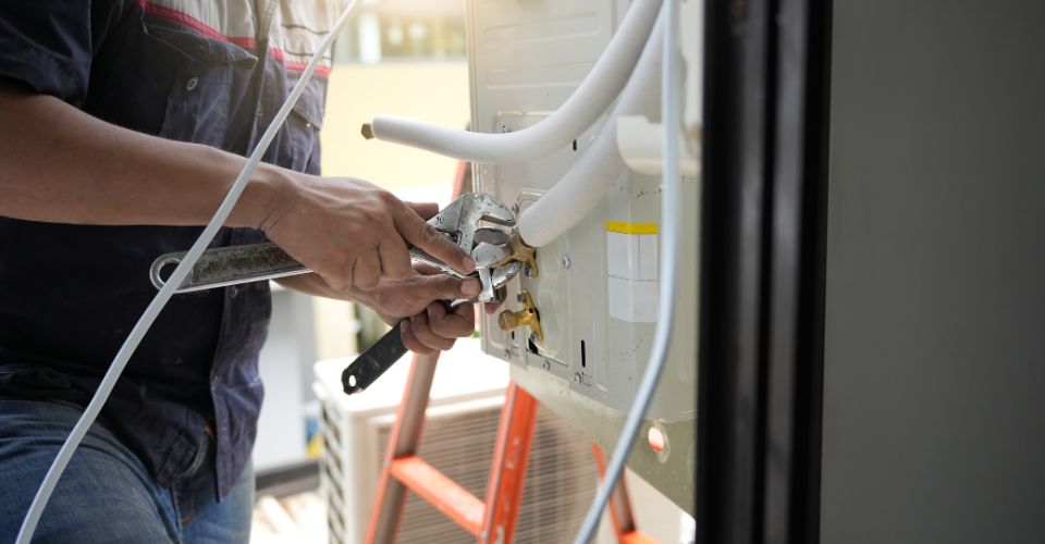 Technician servicing outdoor AC unit
